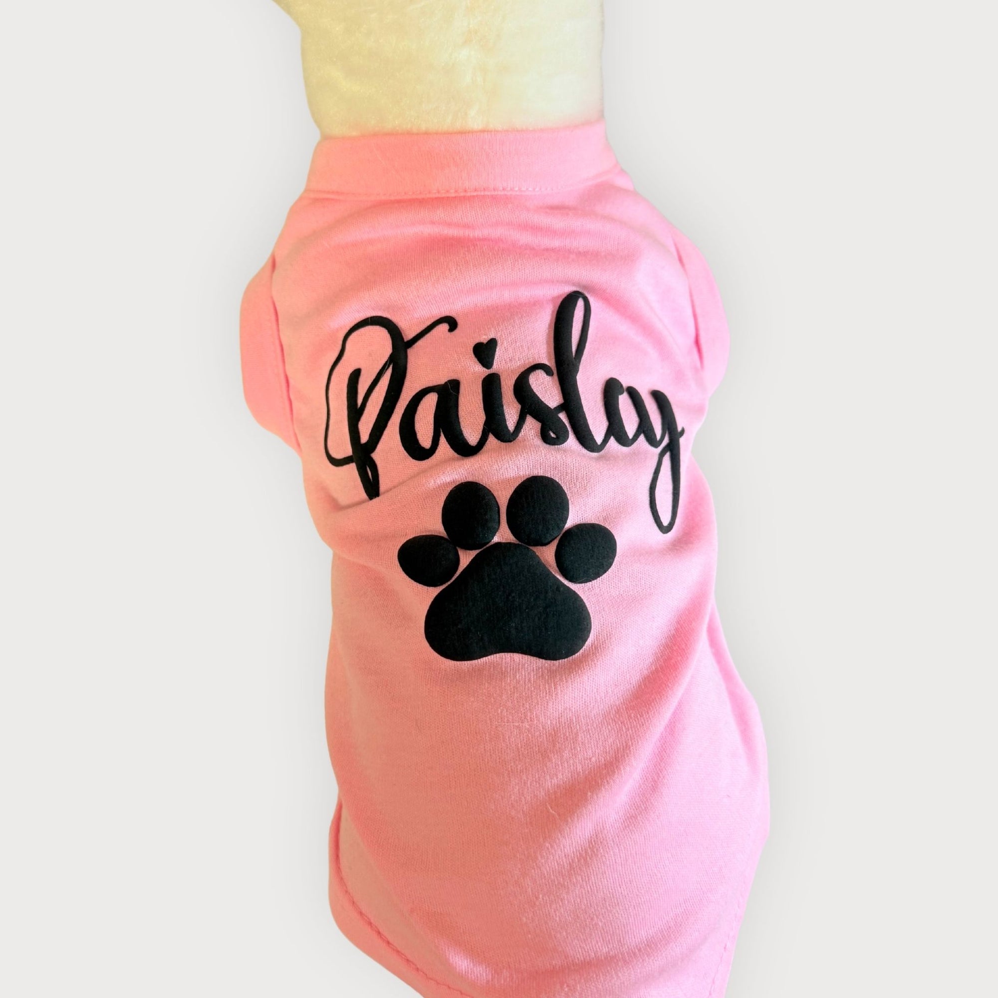 Example of a pink dog shirt customized with name and paw print design using puff vinyl from Fetch Blanks.