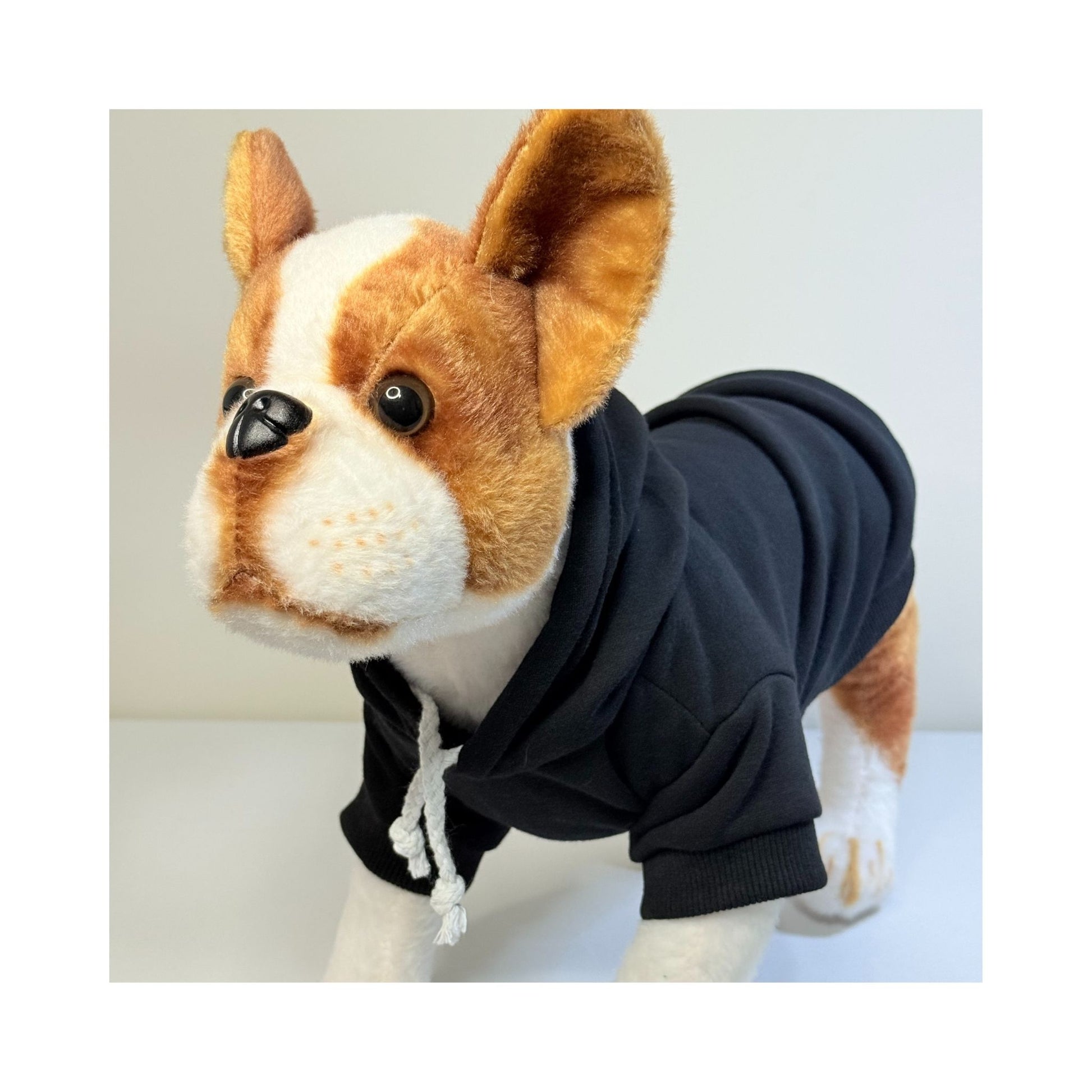 Black blank dog hoodie on stuffed mannequin, front angle showing hood, drawstrings, and snug fit - ideal for custom pet apparel.