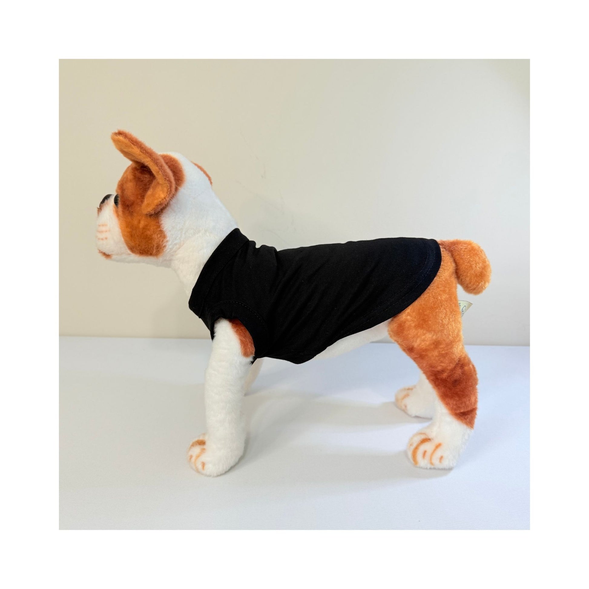 Side profile of stuffed dog wearing a black pet t-shirt - full length and sleeve fit visible