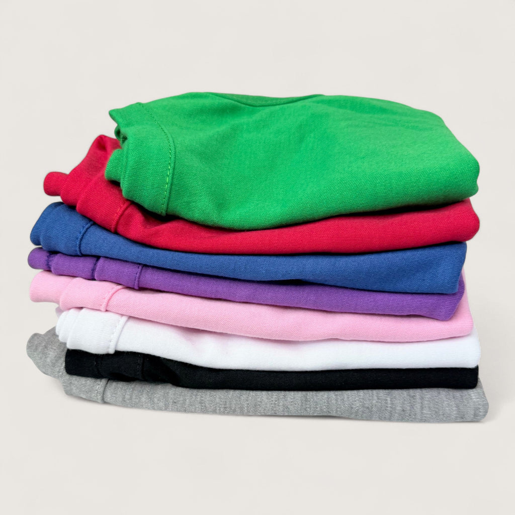 Stack of folded colorful blank dog t-shirts on a light background