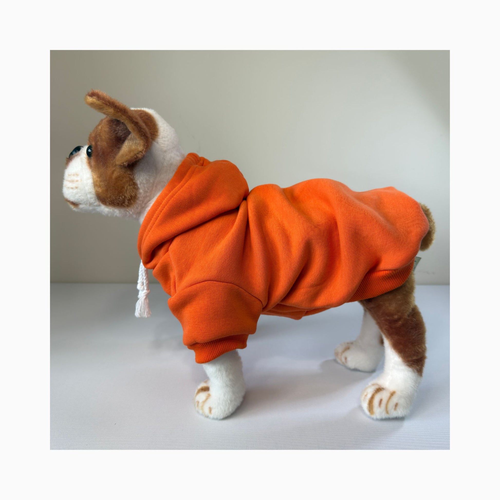 Full side profile of stuffed dog model wearing an orange blank hoodie – ideal for showcasing fit, color, and style for custom pet clothing brands.