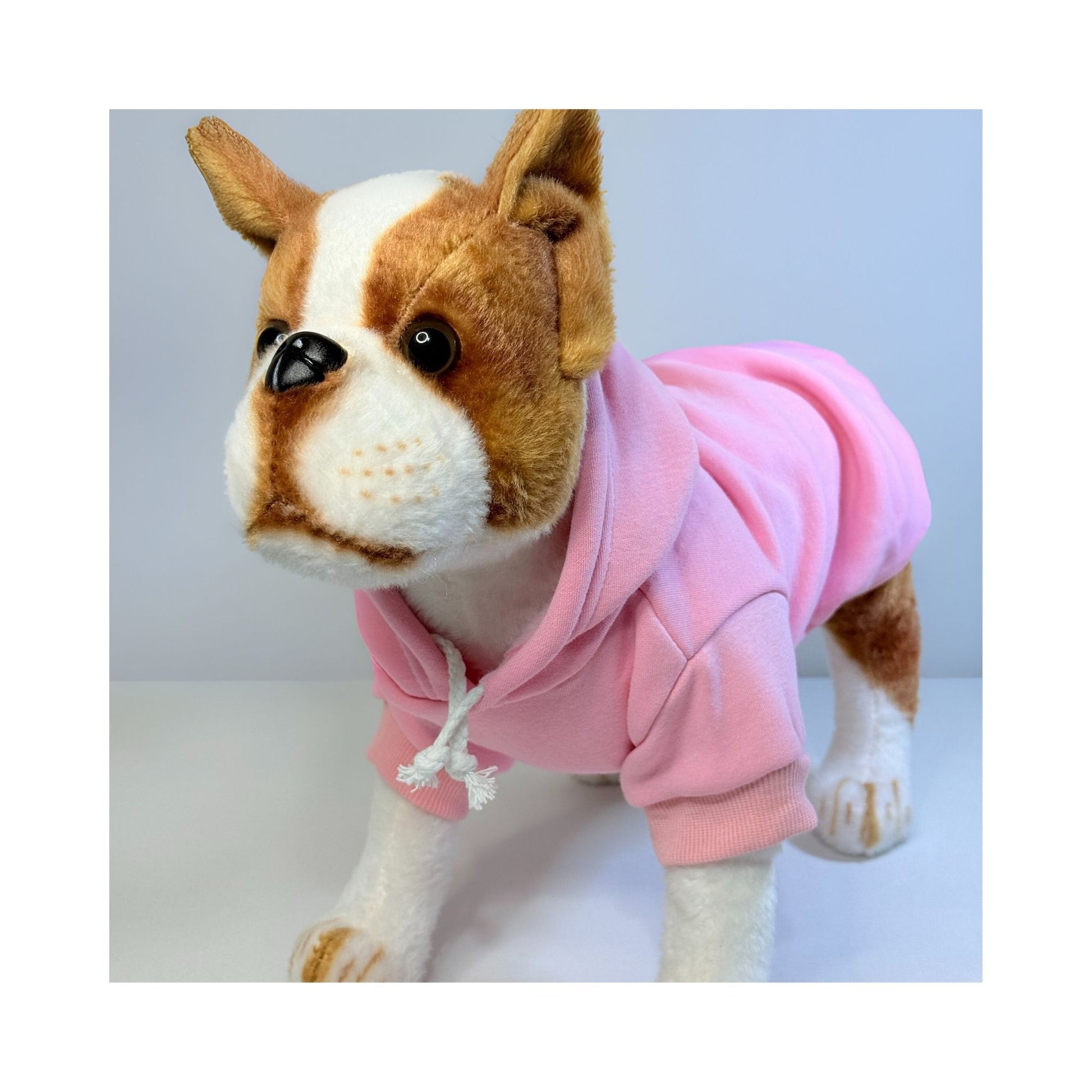Stuffed dog model wearing a pink pet hoodie with hood and drawstrings, shown from the front side angle