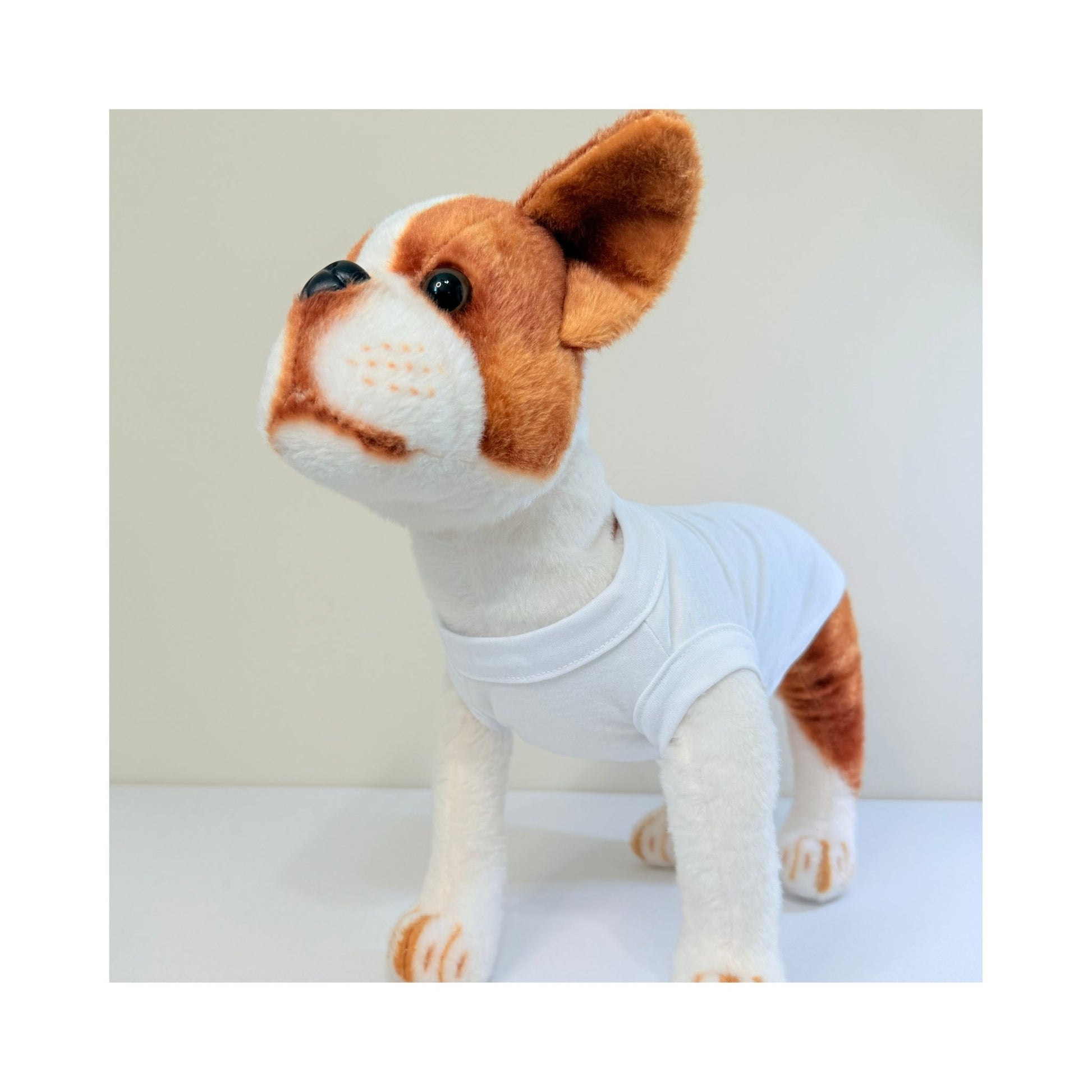 Stuffed dog model wearing a white blank pet t-shirt - front angle showing neckline, sleeves, and chest fit